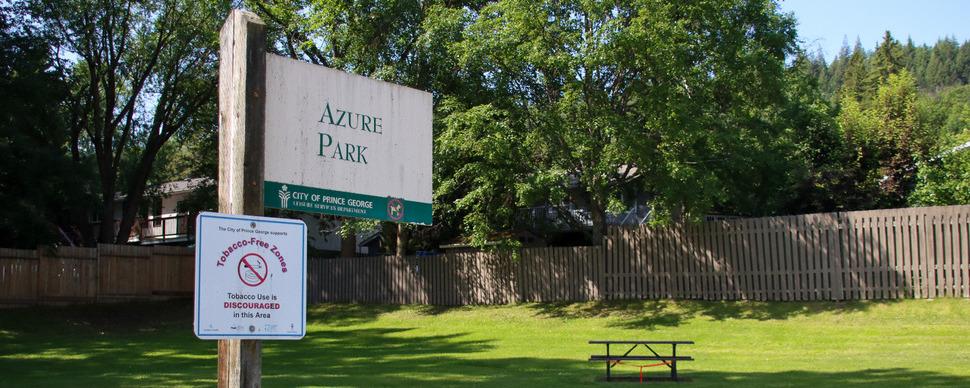 A field with picnic table. Sign in foreground reads 'Azure Park'.